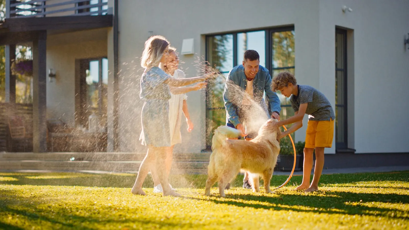 Family playing with golden retriever outdoors